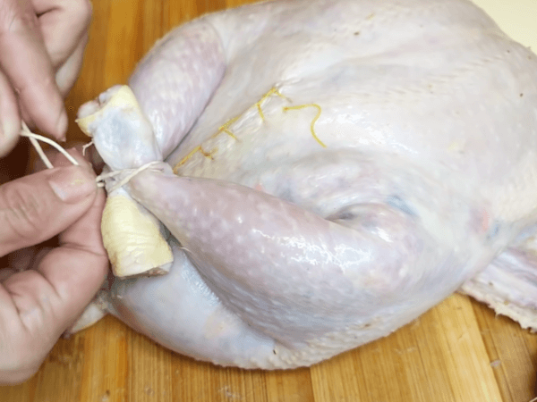 amarrando patas de pollo con hilo