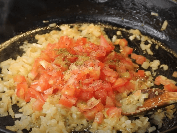 condimentos sofriendo sobre tomate, ajo y cebolla