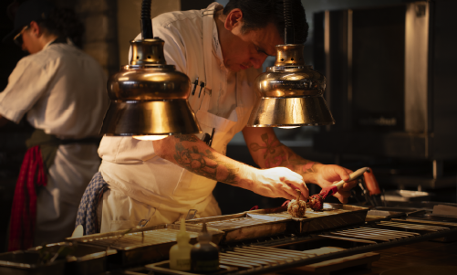 Chef colombiano preparando pollo en cocina profesional